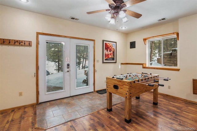 recreation room with dark hardwood / wood-style floors, ceiling fan, and french doors