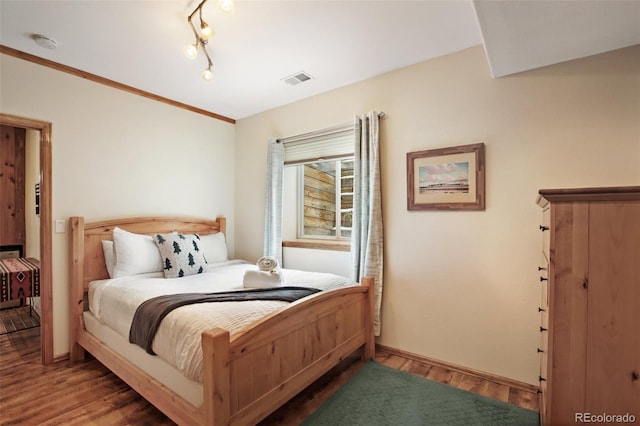 bedroom featuring ornamental molding and hardwood / wood-style floors