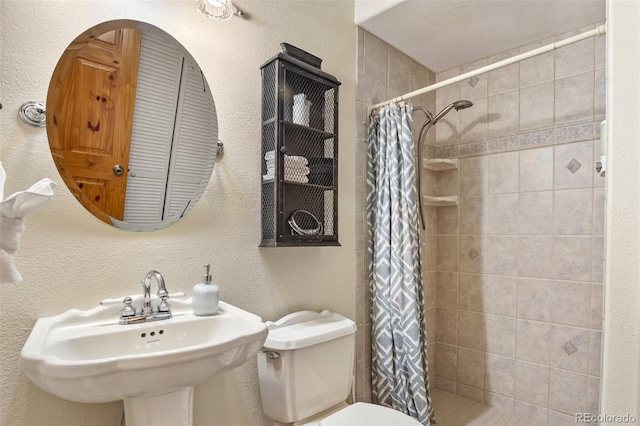 bathroom with sink, curtained shower, and toilet