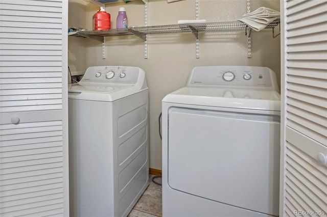 clothes washing area with light tile patterned floors and washer and dryer