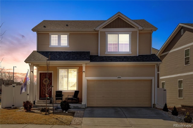 view of front of property with covered porch, driveway, a shingled roof, and a garage