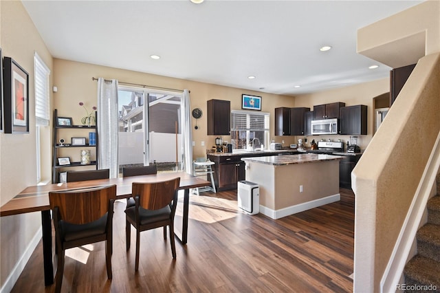 kitchen featuring a center island, dark wood finished floors, recessed lighting, stainless steel appliances, and a sink