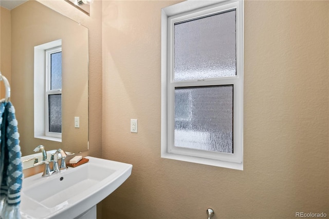 bathroom featuring a sink and a textured wall