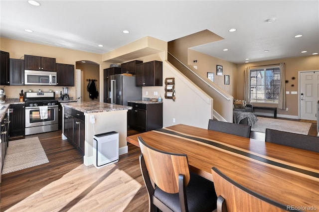 kitchen featuring recessed lighting, wood finished floors, arched walkways, and stainless steel appliances