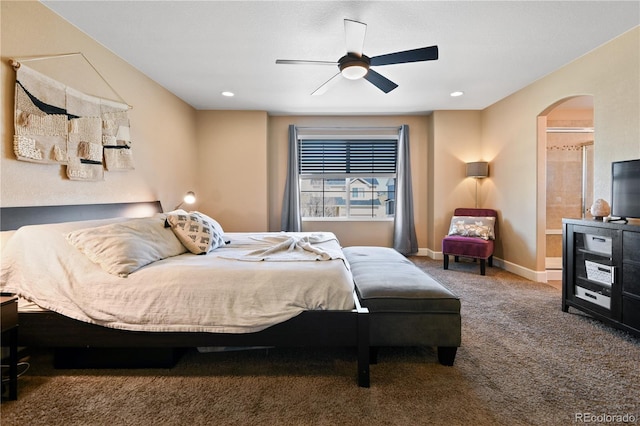 carpeted bedroom with recessed lighting, baseboards, arched walkways, and ensuite bath