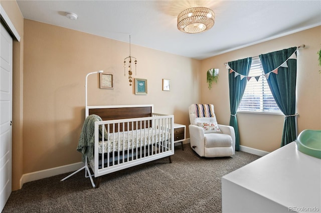 bedroom featuring carpet flooring, a crib, and baseboards