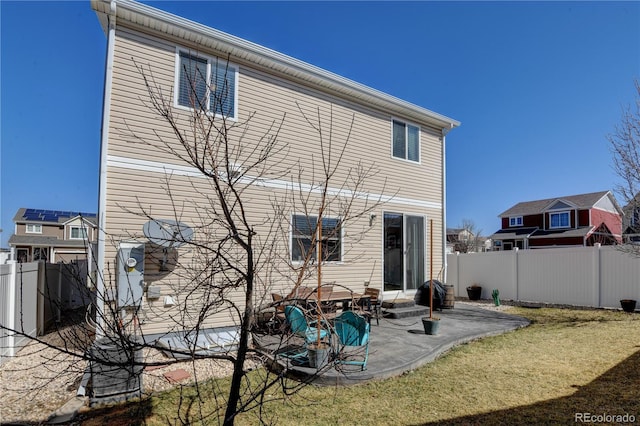 rear view of house with a yard, a patio area, and a fenced backyard