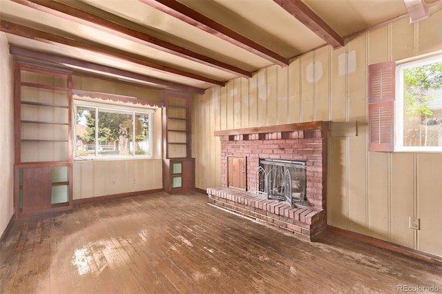 1000 Salem St, Aurora, CO 80011 - unfurnished living room with beamed ceiling, a fireplace, hardwood / wood-style floors, and wooden walls