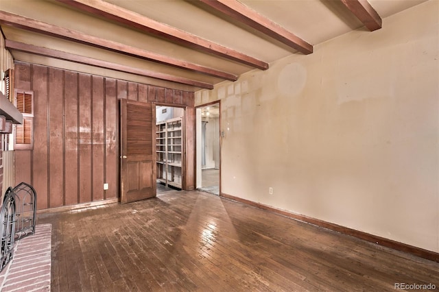 1000 Salem St, Aurora, CO 80011 - unfurnished living room with beam ceiling, dark wood finished floors, wooden walls, and baseboards