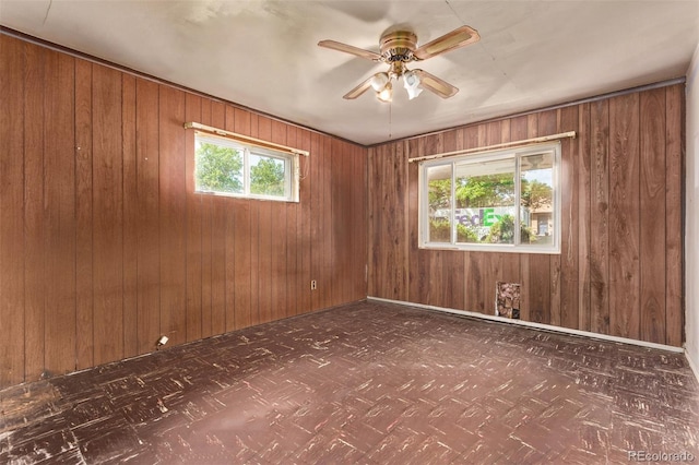 1000 Salem St, Aurora, CO 80011 - unfurnished room featuring tile patterned floors, wooden walls, and a ceiling fan