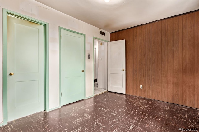 1000 Salem St, Aurora, CO 80011 - unfurnished bedroom with wood walls, a closet, and tile patterned floors
