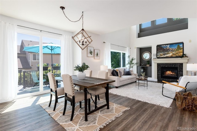 9610 S Dover Way, Littleton, CO 80127 - dining space with dark wood finished floors, a glass covered fireplace, and a chandelier