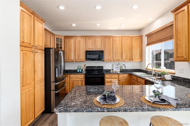 9610 S Dover Way, Littleton, CO 80127 - kitchen featuring black appliances, recessed lighting, a peninsula, dark stone countertops, and dark wood finished floors