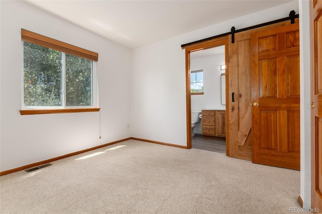 9610 S Dover Way, Littleton, CO 80127 - carpeted empty room with healthy amount of natural light and a barn door