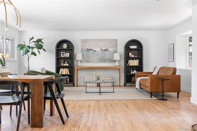 dining area with built in shelves and wood finished floors