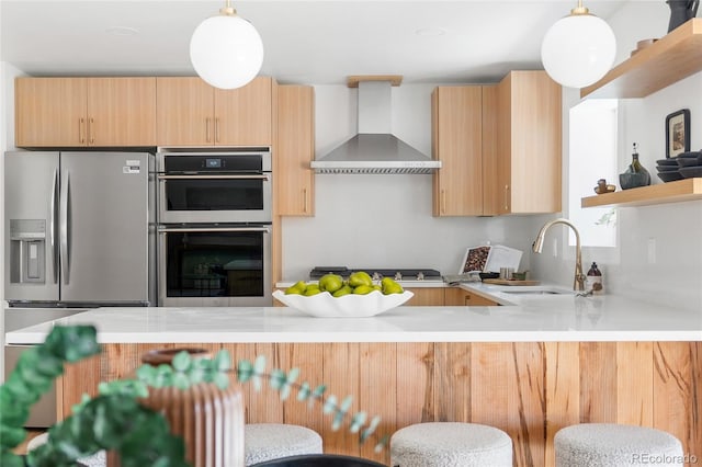 kitchen with open shelves, stainless steel appliances, a sink, light countertops, and wall chimney exhaust hood