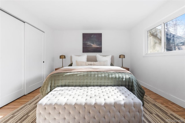 bedroom featuring a closet, baseboards, and wood finished floors