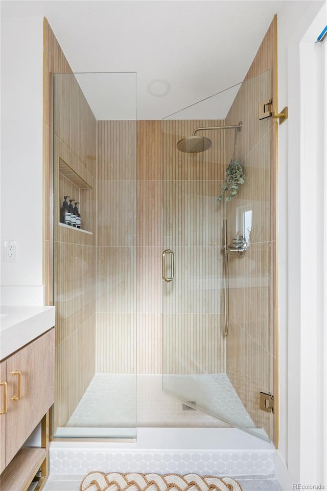 bathroom featuring a shower stall and vanity