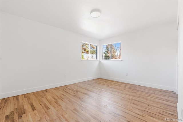 spare room with light wood-style floors and baseboards