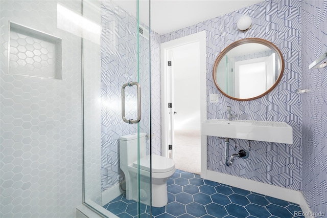 bathroom featuring a shower stall, toilet, and wallpapered walls