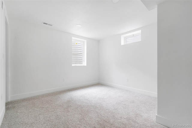 carpeted spare room with visible vents and baseboards