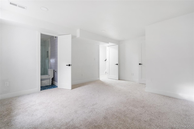 interior space featuring baseboards, carpet, visible vents, and connected bathroom