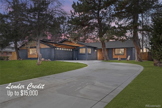 mid-century home featuring concrete driveway, an attached garage, fence, a yard, and brick siding