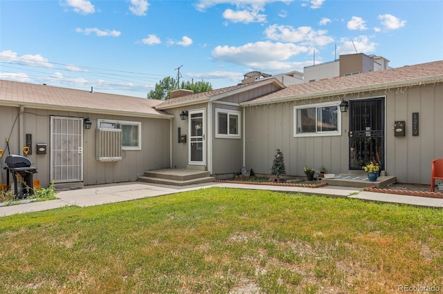 rear view of property with a lawn