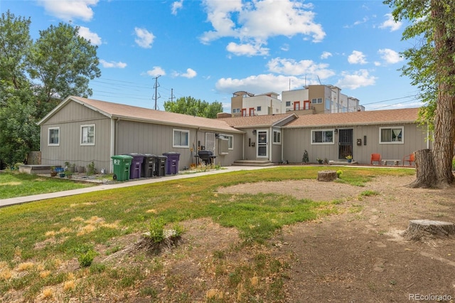 rear view of property featuring a lawn