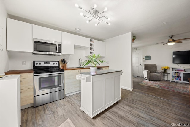 kitchen with stainless steel appliances, a kitchen island, light hardwood / wood-style floors, white cabinets, and ceiling fan with notable chandelier