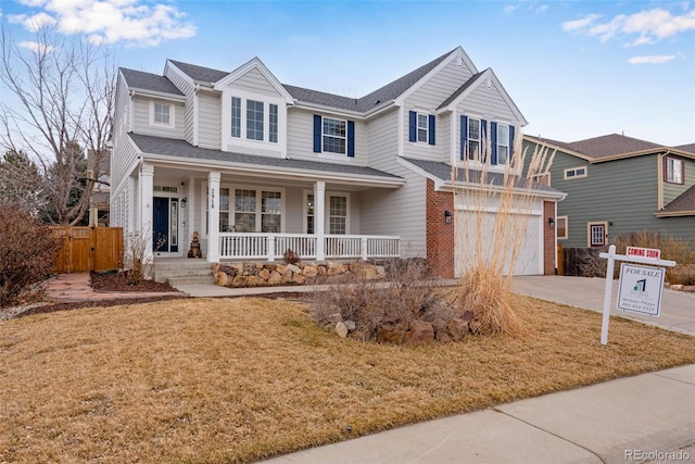 view of front of house featuring covered porch, concrete driveway, an attached garage, a front yard, and fence