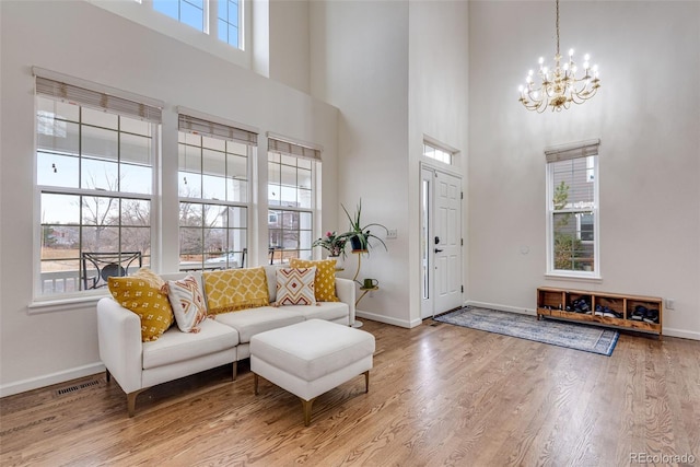 living room with baseboards, visible vents, and wood finished floors