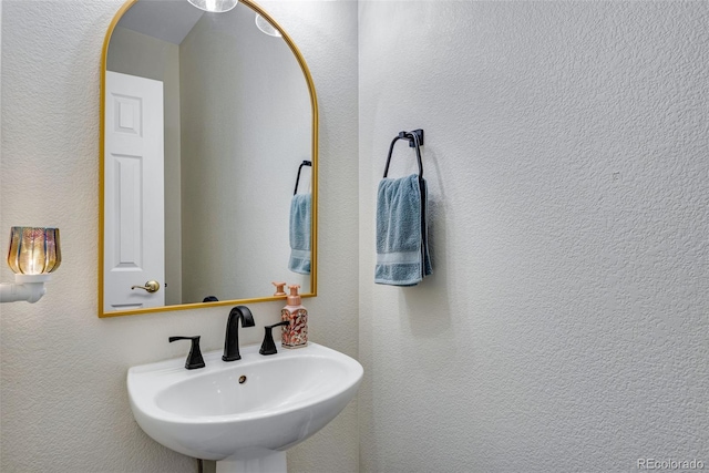 bathroom with a textured wall and a sink