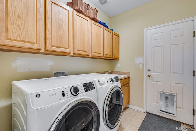 laundry room featuring light floors, washing machine and clothes dryer, cabinet space, a sink, and baseboards