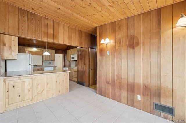 150 Apache Trl, Woodland Park, CO 80863 - kitchen with white appliances, wooden walls, wooden ceiling, brown cabinets, and a peninsula