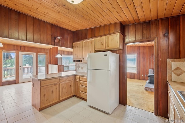 150 Apache Trl, Woodland Park, CO 80863 - kitchen featuring freestanding refrigerator, wood ceiling, a peninsula, light countertops, and wood walls