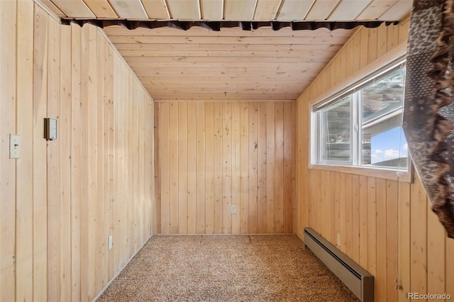 150 Apache Trl, Woodland Park, CO 80863 - spare room featuring a baseboard heating unit, wood walls, carpet floors, and wood ceiling