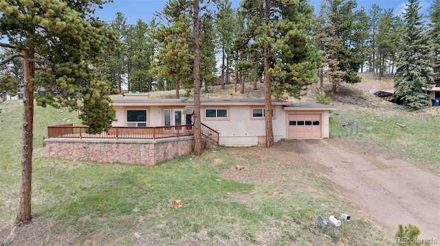150 Apache Trl, Woodland Park, CO 80863 - single story home featuring dirt driveway, a garage, a deck, stucco siding, and a front yard