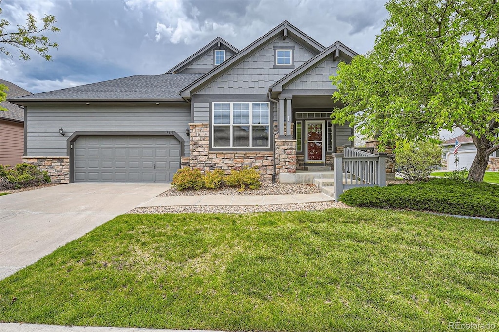 craftsman house featuring a garage and a front lawn