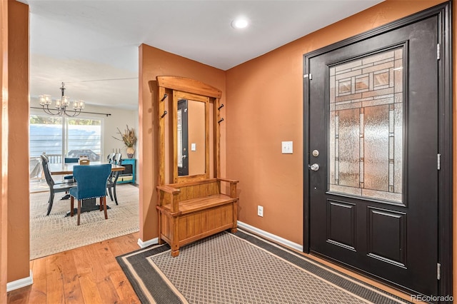 foyer entrance featuring hardwood / wood-style floors and a notable chandelier