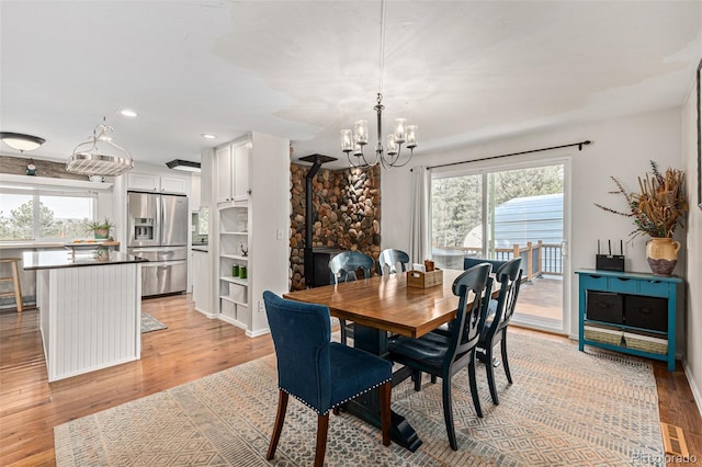 dining space with light hardwood / wood-style flooring and an inviting chandelier