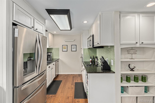 kitchen with light hardwood / wood-style flooring, tasteful backsplash, white cabinetry, and stainless steel appliances