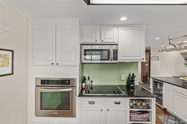 kitchen with white cabinets, tasteful backsplash, and stainless steel appliances