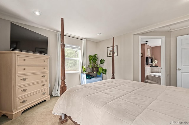 bedroom with light colored carpet and ensuite bath