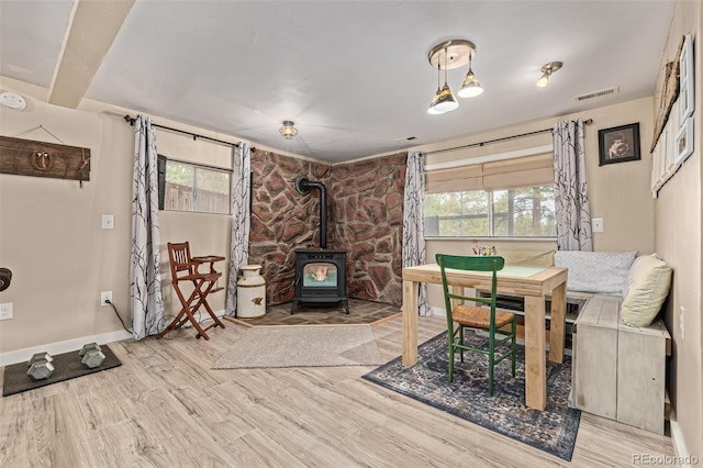 interior space with light hardwood / wood-style flooring, a healthy amount of sunlight, and a wood stove