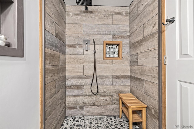 bathroom with wood walls and tiled shower