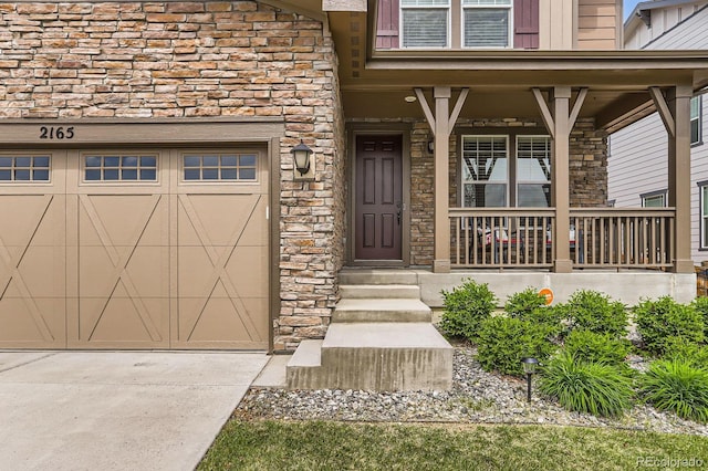 2165 Summerlin Ln, Longmont, CO 80503 - doorway to property with stone siding, a porch, driveway, and an attached garage