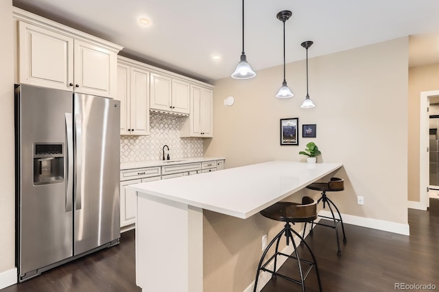 2165 Summerlin Ln, Longmont, CO 80503 - kitchen featuring stainless steel refrigerator with ice dispenser, a breakfast bar area, dark wood finished floors, decorative backsplash, and recessed lighting