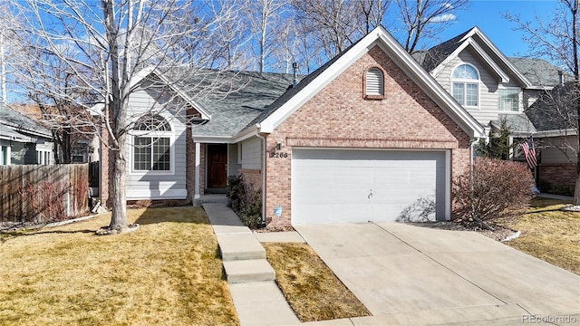 2266 S Kenton St, Aurora, CO 80014 - view of front of house with an attached garage, brick siding, fence, concrete driveway, and a front lawn