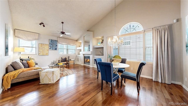 2266 S Kenton St, Aurora, CO 80014 - dining space featuring a textured ceiling, ceiling fan with notable chandelier, hardwood / wood-style floors, and a glass covered fireplace